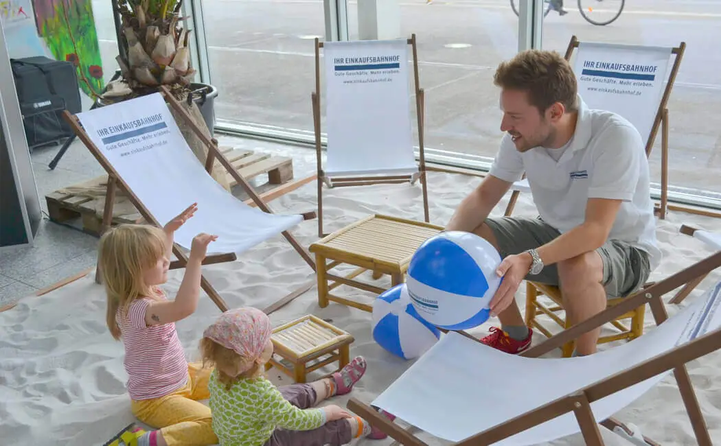 Kinder spielen mit Wasserbällen im Sand