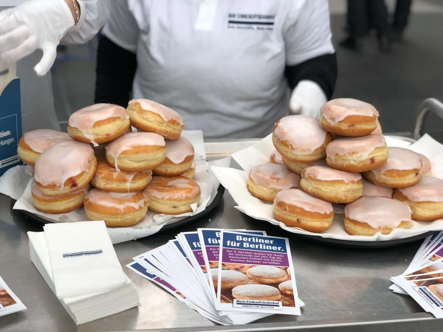 Teller mit Berliner Pfannkuchen und Flyern bei der Promotion-Aktion am Bahnhof