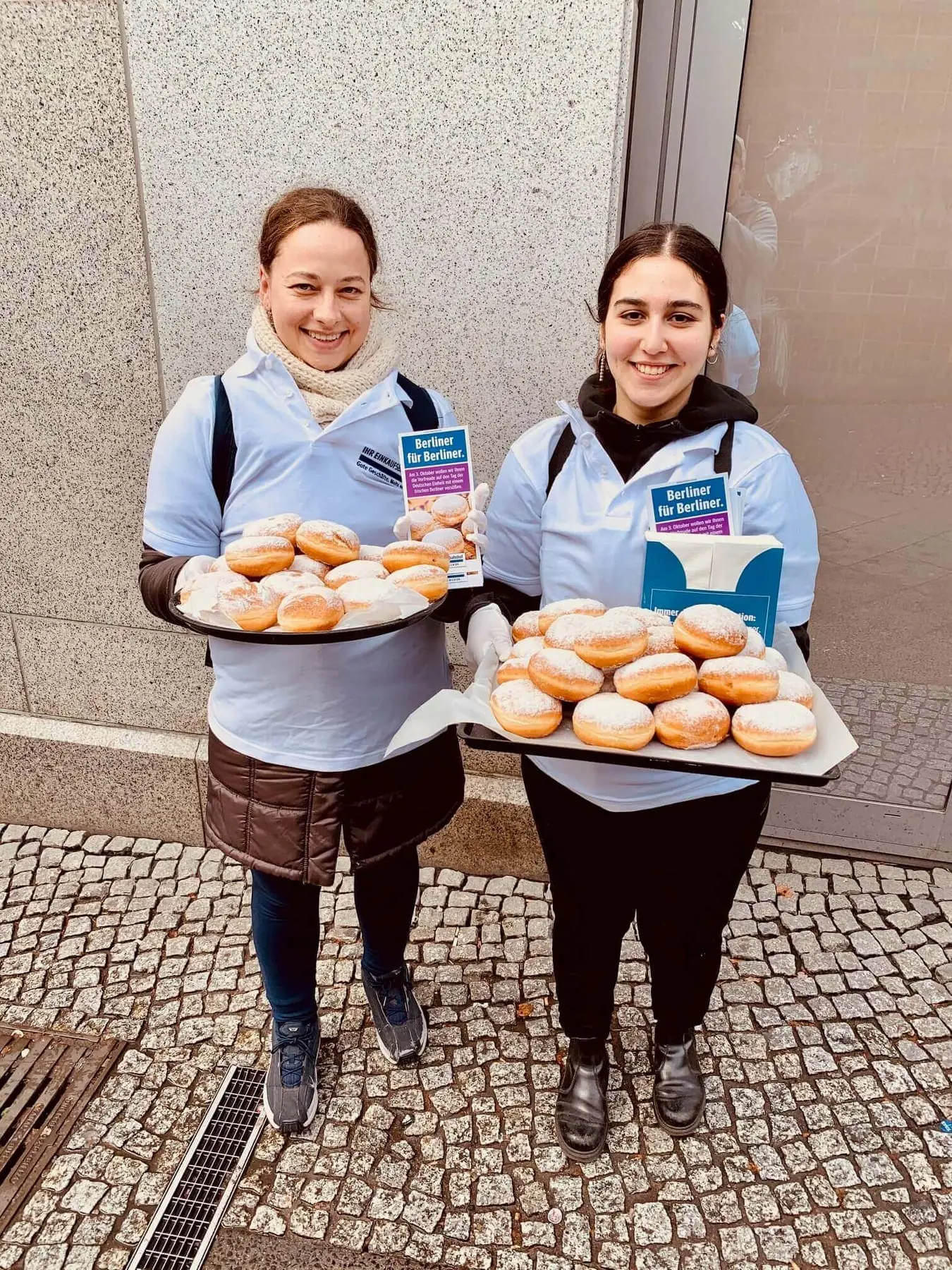 Zwei Promoterinnen mit Tabletts voller Pfannkuchen im Bahnhof